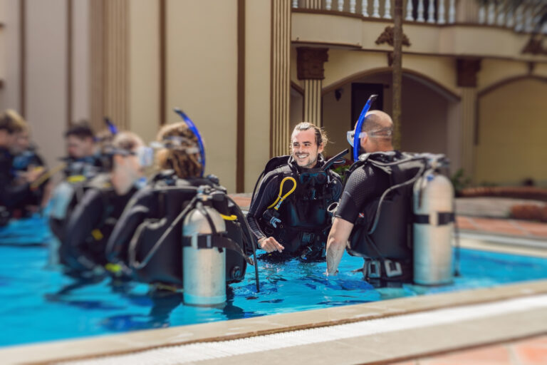 Diving instructor and students. Instructor teaches students to dive.